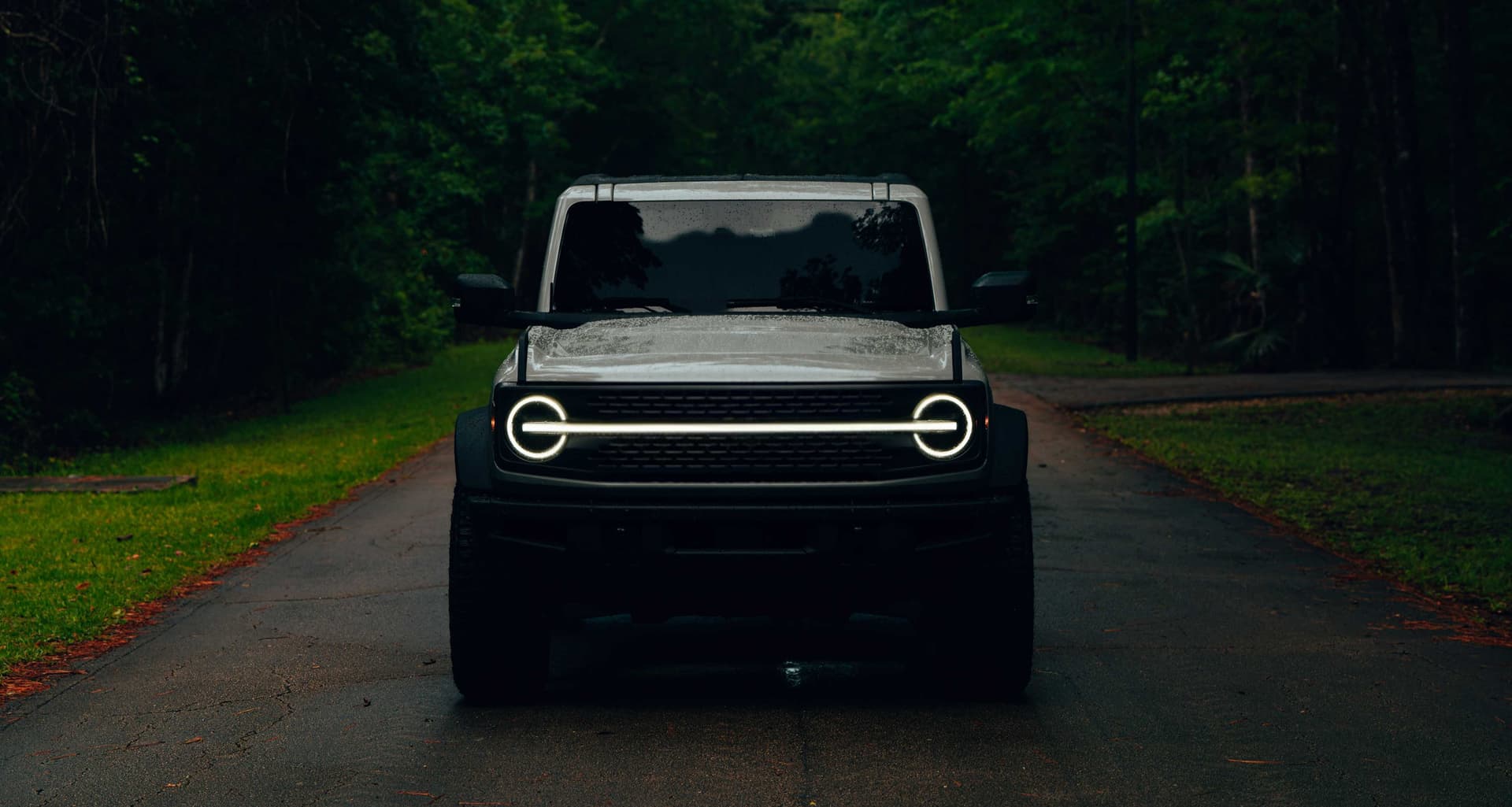 Electric Vehicle with glowing headlights on a dark road